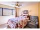 Bedroom showcasing a ceiling fan and a large, bright window with neutral decor and an armchair at 100 N Vulture Mine Rd # 103, Wickenburg, AZ 85390