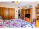 Bedroom with a ceiling fan, wooden closet, and shelves with a view to the living area at 100 N Vulture Mine Rd # 103, Wickenburg, AZ 85390