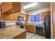 Well-lit kitchen features wood cabinets and countertops with black appliances and window at 100 N Vulture Mine Rd # 103, Wickenburg, AZ 85390