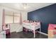 Cozy bedroom with a blue accent wall, lofted bed, and a window providing natural light at 1146 N 89Th St, Mesa, AZ 85207