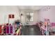 Bright ' room featuring wood floors, a window, playful decor, and pink and white walls at 1146 N 89Th St, Mesa, AZ 85207