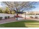 Serene backyard space with a modern pergola under a mature tree and lush artificial grass at 11628 S Warcloud Ct, Phoenix, AZ 85044