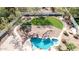 A sprawling backyard with a sparkling pool, rock features, lush lawn, and desert landscaping at 11628 S Warcloud Ct, Phoenix, AZ 85044