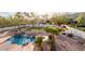 Aerial view of a tropical backyard oasis featuring a large pool, rock waterfalls, and lush landscaping at 11628 S Warcloud Ct, Phoenix, AZ 85044