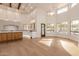 Open-concept living room with hardwood floors, recessed lighting, and large windows overlooking the pool area at 11628 S Warcloud Ct, Phoenix, AZ 85044