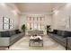 Living room featuring neutral furniture, designer lighting, and a bay window overlooking the backyard at 11628 S Warcloud Ct, Phoenix, AZ 85044