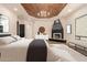 Spacious main bedroom with a fireplace, wood tray ceiling, and neutral decor at 11628 S Warcloud Ct, Phoenix, AZ 85044