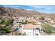 An exterior view of a home, showcasing a pool, desert landscaping, and mountain views in the background at 11628 S Warcloud Ct, Phoenix, AZ 85044