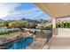 Balcony view overlooking a pool, lush landscaping, and desert mountains, creating a serene outdoor experience at 11628 S Warcloud Ct, Phoenix, AZ 85044