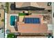 This aerial view features solar panels on a roof, a pool, and artificial turf in a manicured backyard at 11954 W Melinda Ln, Sun City, AZ 85373