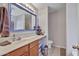 Bathroom featuring a spacious vanity, bright lighting, decorative mirror, and toilet at 11954 W Melinda Ln, Sun City, AZ 85373