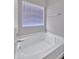 Bright, clean white bathtub with a window, offering a relaxing space for homeowners at 11954 W Melinda Ln, Sun City, AZ 85373