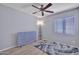 A bright bedroom featuring sleek flooring, a modern ceiling fan, and a window with blinds at 11954 W Melinda Ln, Sun City, AZ 85373