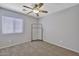 Neutral bedroom with carpet flooring, a ceiling fan, a window, and a clothing rack for additional storage at 11954 W Melinda Ln, Sun City, AZ 85373