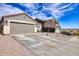 Single-story home featuring a two-car garage and desert landscape, set against a vibrant blue sky with light cloud cover at 11954 W Melinda Ln, Sun City, AZ 85373