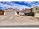 Single-story home featuring a desert landscape, neutral color palette, two-car garage and tile roofing under a bright blue sky at 11954 W Melinda Ln, Sun City, AZ 85373