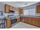 Functional kitchen with stainless steel appliances, natural wood cabinets, and tiled floors under track lighting at 11954 W Melinda Ln, Sun City, AZ 85373