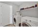 Well-lit laundry room features washer, dryer, built-in shelf and white door with door knob at 11954 W Melinda Ln, Sun City, AZ 85373