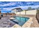 Sparkling swimming pool with stone tile surround and decorative water feature at 11954 W Melinda Ln, Sun City, AZ 85373