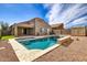 Backyard pool with water feature, desert landscaping, and covered patio at 11954 W Melinda Ln, Sun City, AZ 85373