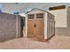 Outdoor backyard storage shed, with gravel base and privacy wall at 11954 W Melinda Ln, Sun City, AZ 85373