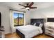 Cozy bedroom featuring a black upholstered bed, view to the outside, and bright natural light at 12026 N 138Th St, Scottsdale, AZ 85259