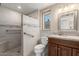 Updated bathroom with stone tile shower featuring grab bar and a wood vanity at 12539 W Paintbrush Dr, Sun City West, AZ 85375