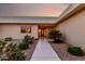 Charming single-story home with landscaped front yard and decorative front door under a colorful sunset sky at 12539 W Paintbrush Dr, Sun City West, AZ 85375