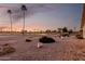 Picturesque sunset view of the golf course, showcasing palm trees and a tranquil pond at 12539 W Paintbrush Dr, Sun City West, AZ 85375