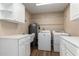 Well-lit laundry room with updated cabinets, countertops, sink, and modern washer and dryer at 12539 W Paintbrush Dr, Sun City West, AZ 85375