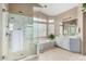 Bright bathroom with a glass-enclosed shower, soaking tub, dual sinks, and natural light at 13566 N 93Rd Pl, Scottsdale, AZ 85260