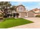 Two-story home featuring a well-manicured lawn and a three-car garage, offering curb appeal at 13566 N 93Rd Pl, Scottsdale, AZ 85260