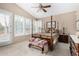 Cozy main bedroom with a four-poster bed, ceiling fan, and bright natural light from the windows at 13566 N 93Rd Pl, Scottsdale, AZ 85260