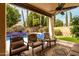 Covered patio features an outdoor ceiling fan, seating with views of the pool and landscaped backyard at 13566 N 93Rd Pl, Scottsdale, AZ 85260