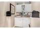 Cozy wet bar area with white cabinetry, granite countertops, and mirrored backsplash at 13566 N 93Rd Pl, Scottsdale, AZ 85260