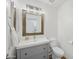 Bathroom features vanity with drawers, a square framed mirror, and white sink and toilet at 1447 S Portland Ave, Gilbert, AZ 85296