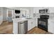 Modern kitchen with white cabinetry, stainless steel appliances, island with sink, and decorative backsplash at 1447 S Portland Ave, Gilbert, AZ 85296