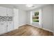 Bright kitchenette features white cabinetry, tiled backsplash, wood floors, and natural light at 1447 S Portland Ave, Gilbert, AZ 85296