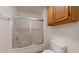 A well-lit bathroom features a shower with glass doors and a wooden cabinet for storage at 1645 W Baseline Rd # 2050, Mesa, AZ 85202