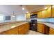 Well-lit kitchen featuring wood cabinets, neutral countertops, and modern appliances at 1645 W Baseline Rd # 2050, Mesa, AZ 85202