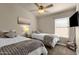 This cozy bedroom features two twin beds, a ceiling fan, and natural light at 16808 N 59Th Pl, Scottsdale, AZ 85254