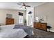 A cozy bedroom with a ceiling fan, a large window, and dresser at 16808 N 59Th Pl, Scottsdale, AZ 85254