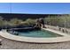 Serene pool with landscaping and a rock waterfall feature, framed by a fence and manicured greenery at 17012 S 27Th Ln, Phoenix, AZ 85045