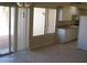 Bright kitchen featuring tile flooring, white cabinets, and a sliding glass door to the patio at 17019 N Pinion Ln, Sun City, AZ 85373