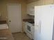 A well-equipped kitchen includes white appliances, a tile floor, and ample cabinet space at 17019 N Pinion Ln, Sun City, AZ 85373