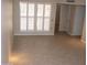 A bright living room featuring neutral walls, tile flooring, and shuttered windows for natural light at 17019 N Pinion Ln, Sun City, AZ 85373