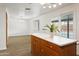 Kitchen island with marble countertop and natural wood cabinetry, flowing to the dining area and backyard pool at 1730 W Pershing Ave, Phoenix, AZ 85029