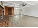 Spacious living room with wood-look tile flooring, rustic brick fireplace, and a ceiling fan at 1730 W Pershing Ave, Phoenix, AZ 85029