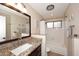 Bright bathroom featuring a granite countertop, framed mirror, and a shower-tub combination with a window at 1920 E Manzanita Dr, Phoenix, AZ 85020