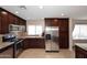 A well-lit kitchen featuring stainless steel appliances, dark wood cabinets, and granite countertops at 1920 E Manzanita Dr, Phoenix, AZ 85020